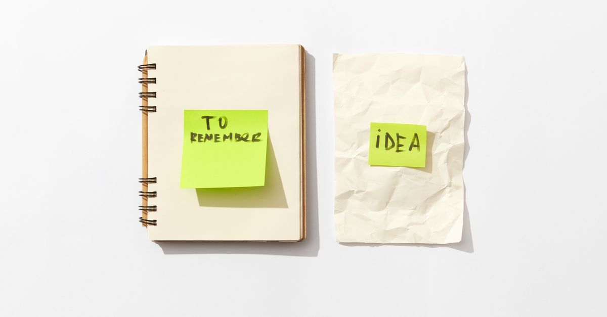 Minimalist flat lay of a notebook and sticky notes for idea organization.